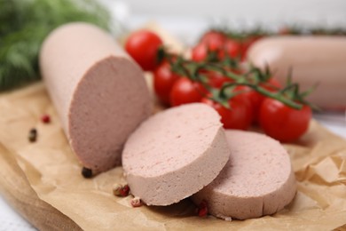 Delicious liver sausages and other products on white wooden table, closeup