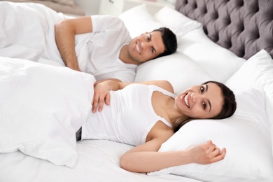 Photo of Lovely young couple resting on large comfortable bed