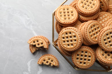 Photo of Tasty sandwich cookies with cream on grey table, flat lay. Space for text