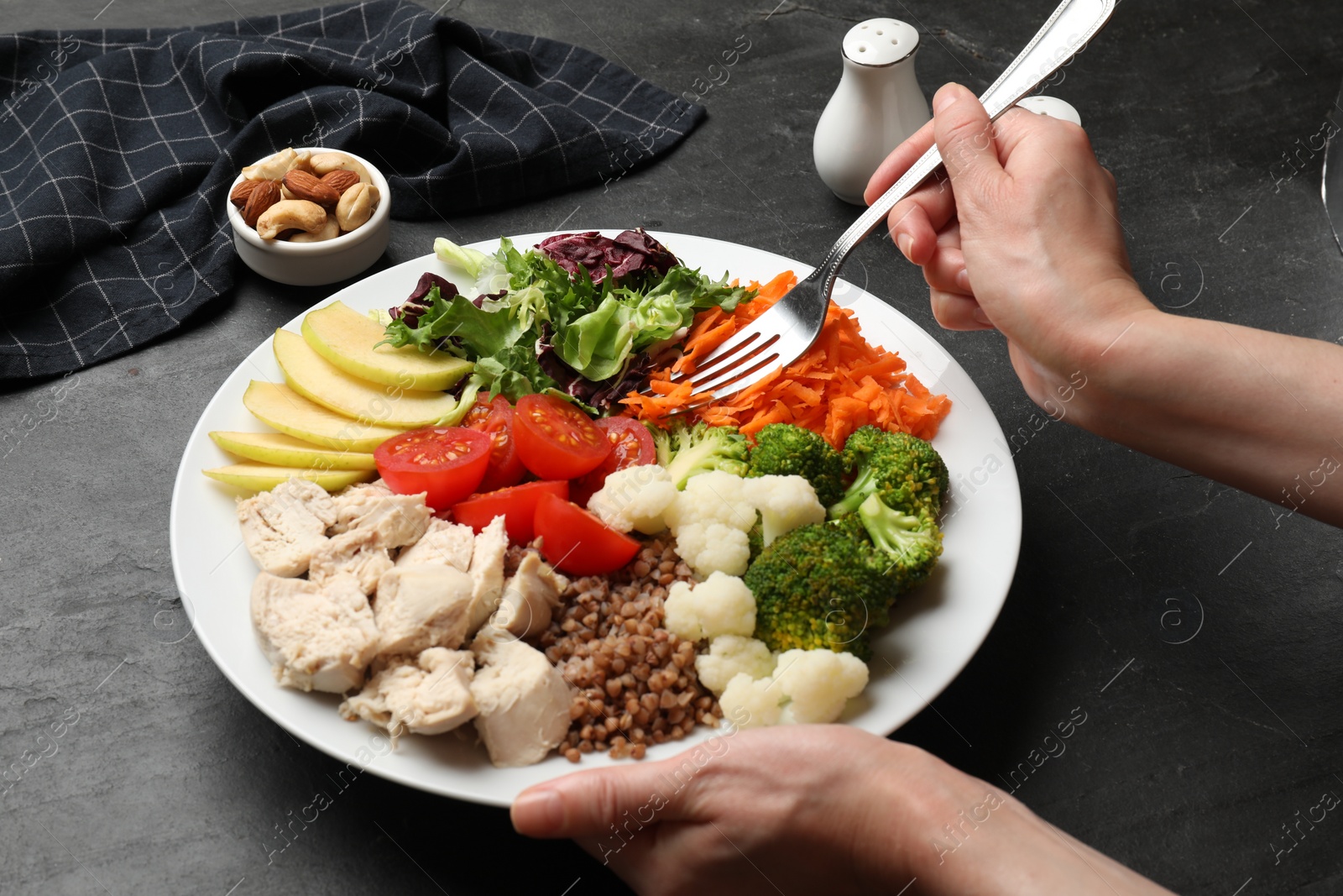 Photo of Balanced diet and healthy foods. Woman eating dinner at black table, closeup