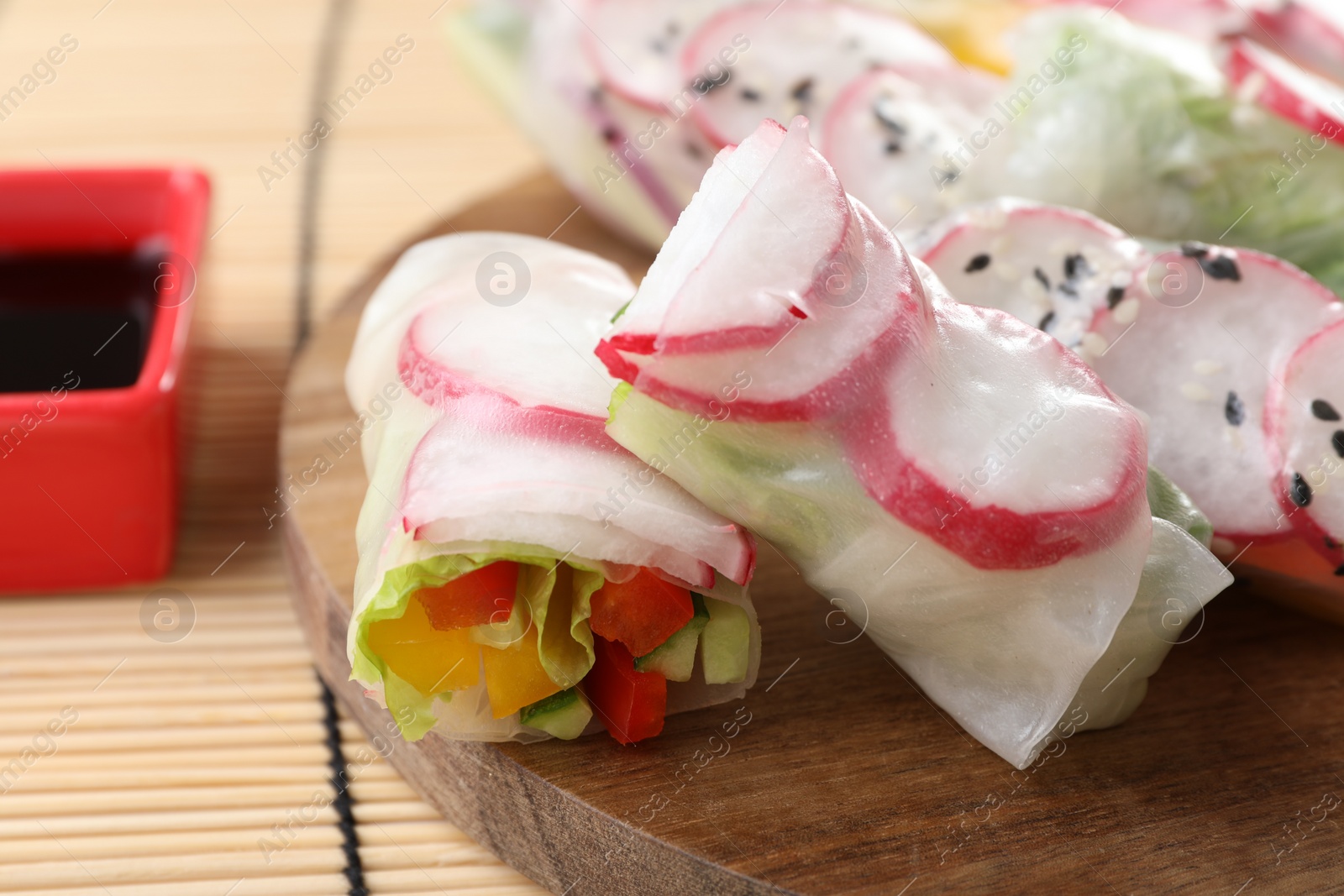 Photo of Delicious spring rolls and soy sauce on table, closeup