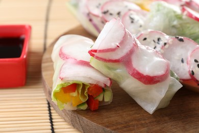 Delicious spring rolls and soy sauce on table, closeup