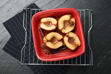 Photo of Tasty baked quinces with anise and honey in dish on black table, top view