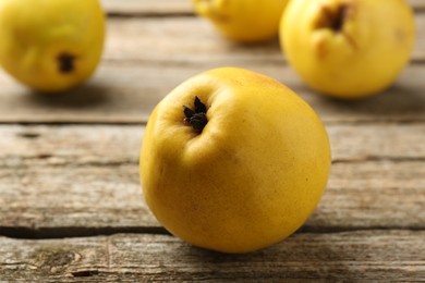 Photo of Tasty ripe quinces on wooden table, closeup