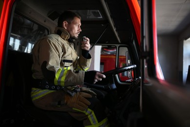 Firefighter using portable radio set while driving fire truck