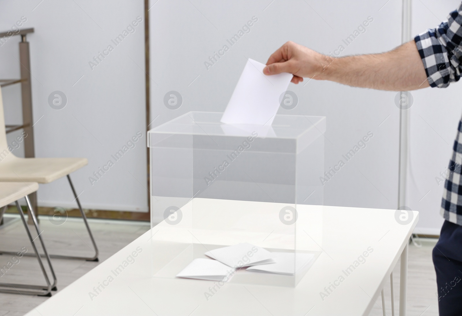 Photo of Man putting his vote into ballot box at polling station, closeup. Space for text