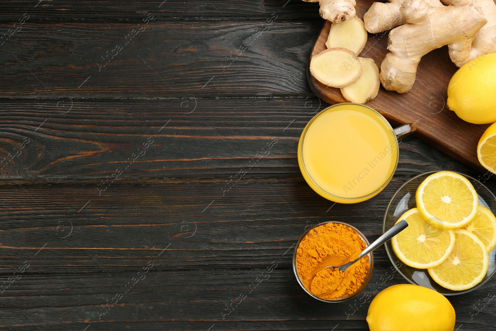 Photo of Flat lay composition with immunity boosting drink and ingredients on dark wooden table. Space for text