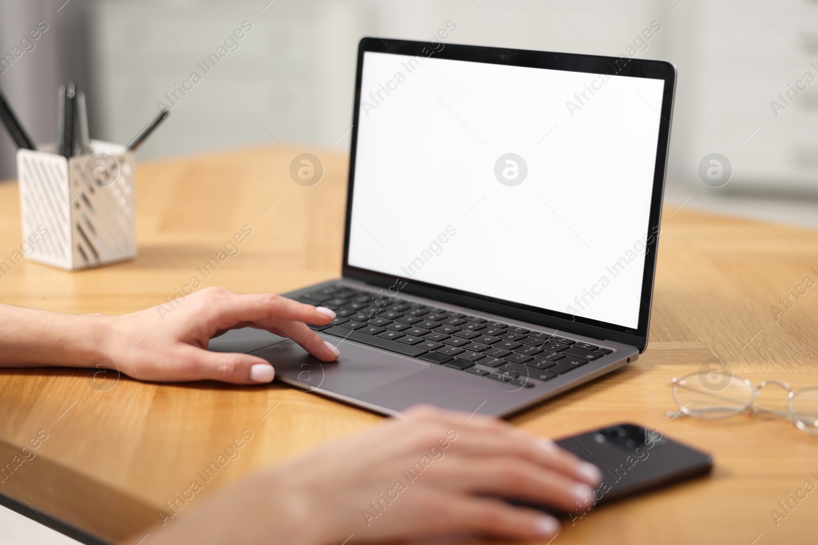 Photo of Young woman watching webinar at table indoors, closeup