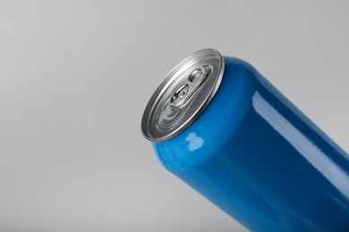 Photo of Blue can of energy drink on light grey background, closeup. Space for text