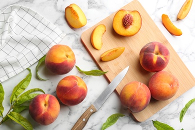 Flat lay composition with fresh sweet peaches on white marble table