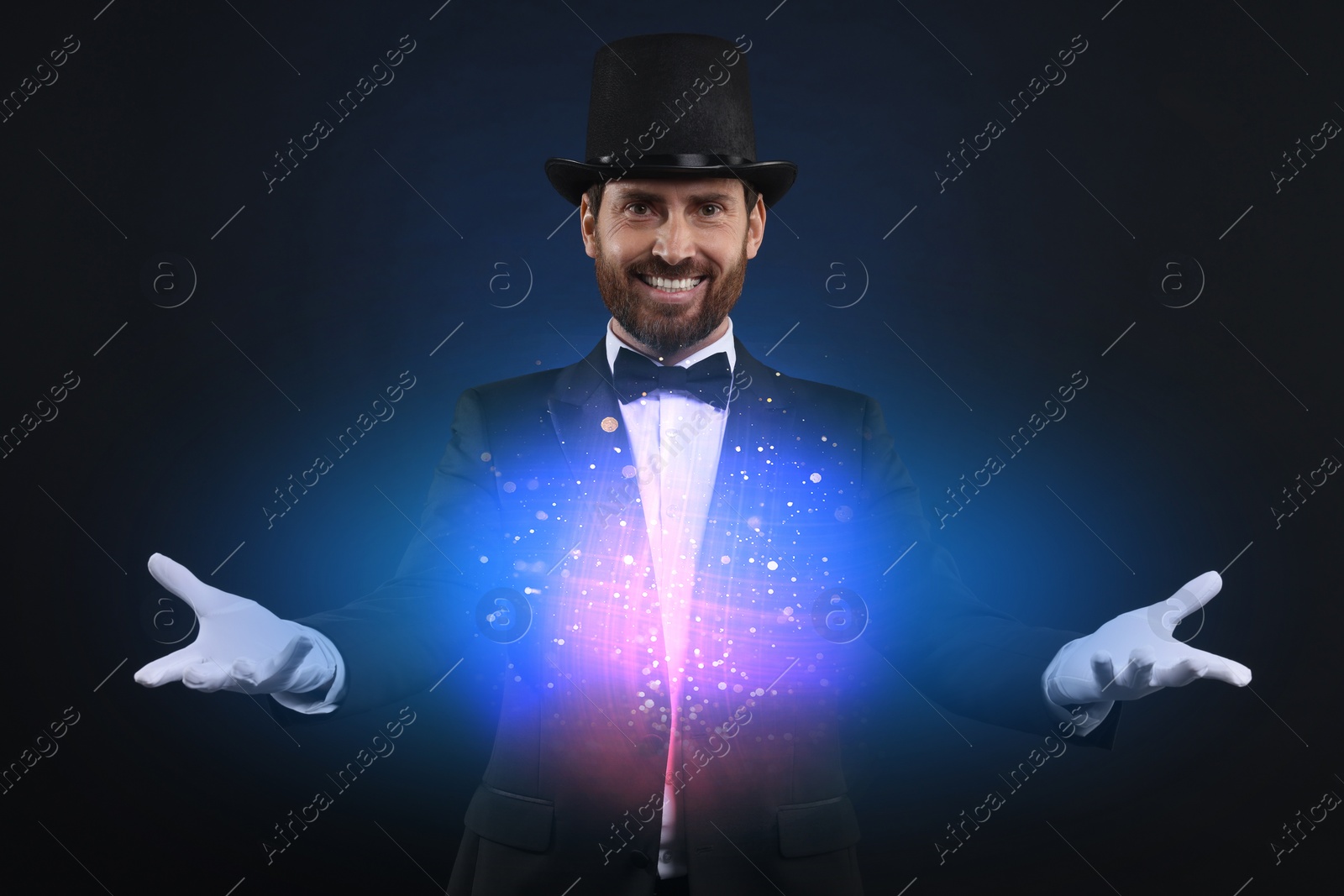 Image of Magic and sorcery. Magician with fantastic light on dark background
