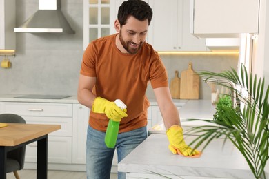 Photo of Spring cleaning. Man tidying up kitchen at home