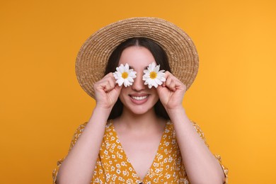 Woman covering her eyes with spring flowers on yellow background
