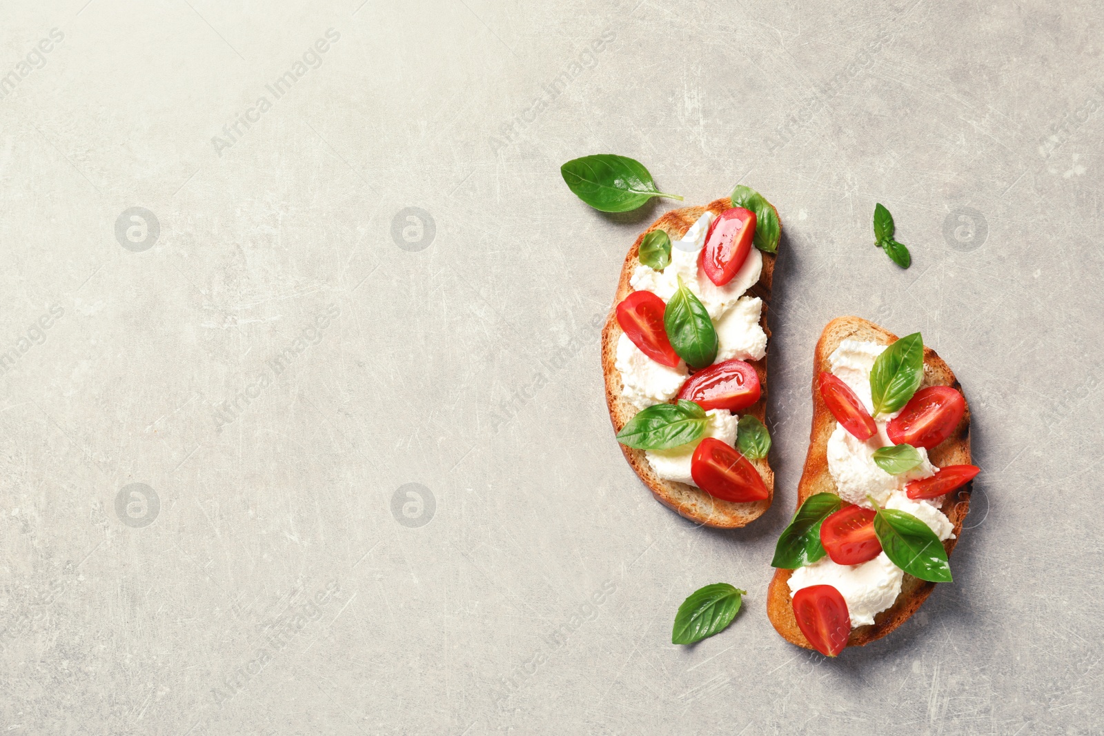 Photo of Toasted bread with tasty cream cheese and tomatoes on gray background, flat lay. Space for text