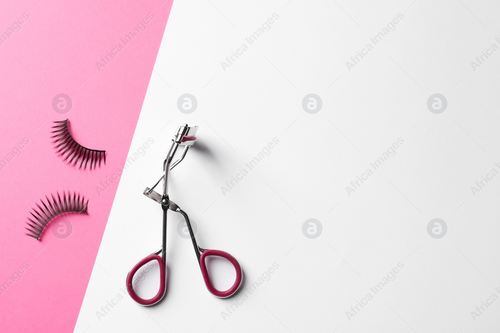 Photo of False eyelashes and curler on color background, flat lay. Space for text