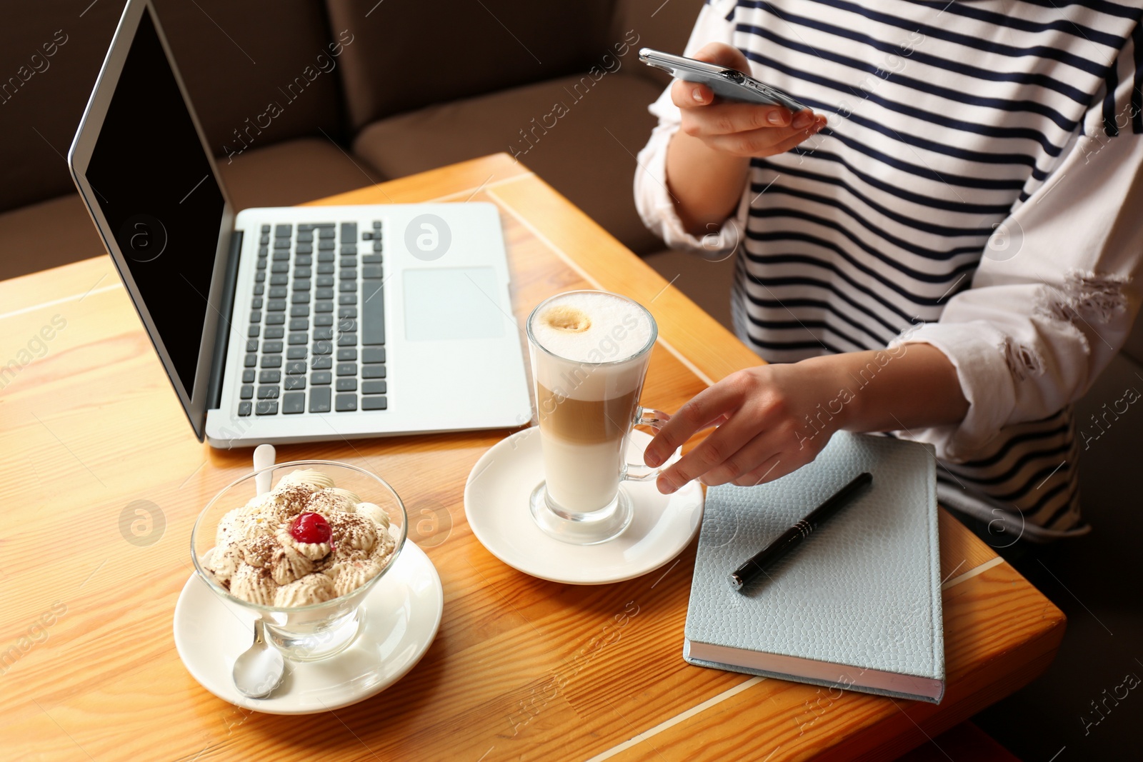 Photo of Blogger taking picture of dessert and coffee at table in office