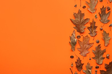 Photo of Dry autumn leaves on orange background, flat lay. Space for text