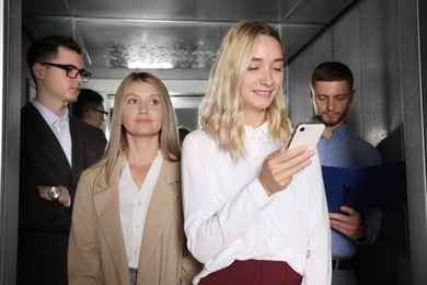 Photo of Group of office workers in modern elevator