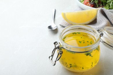 Jar with lemon sauce on light table, space for text. Delicious salad dressing