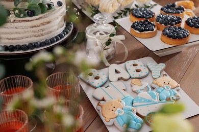 Photo of Beautiful cake and other treats on table. Baby shower party