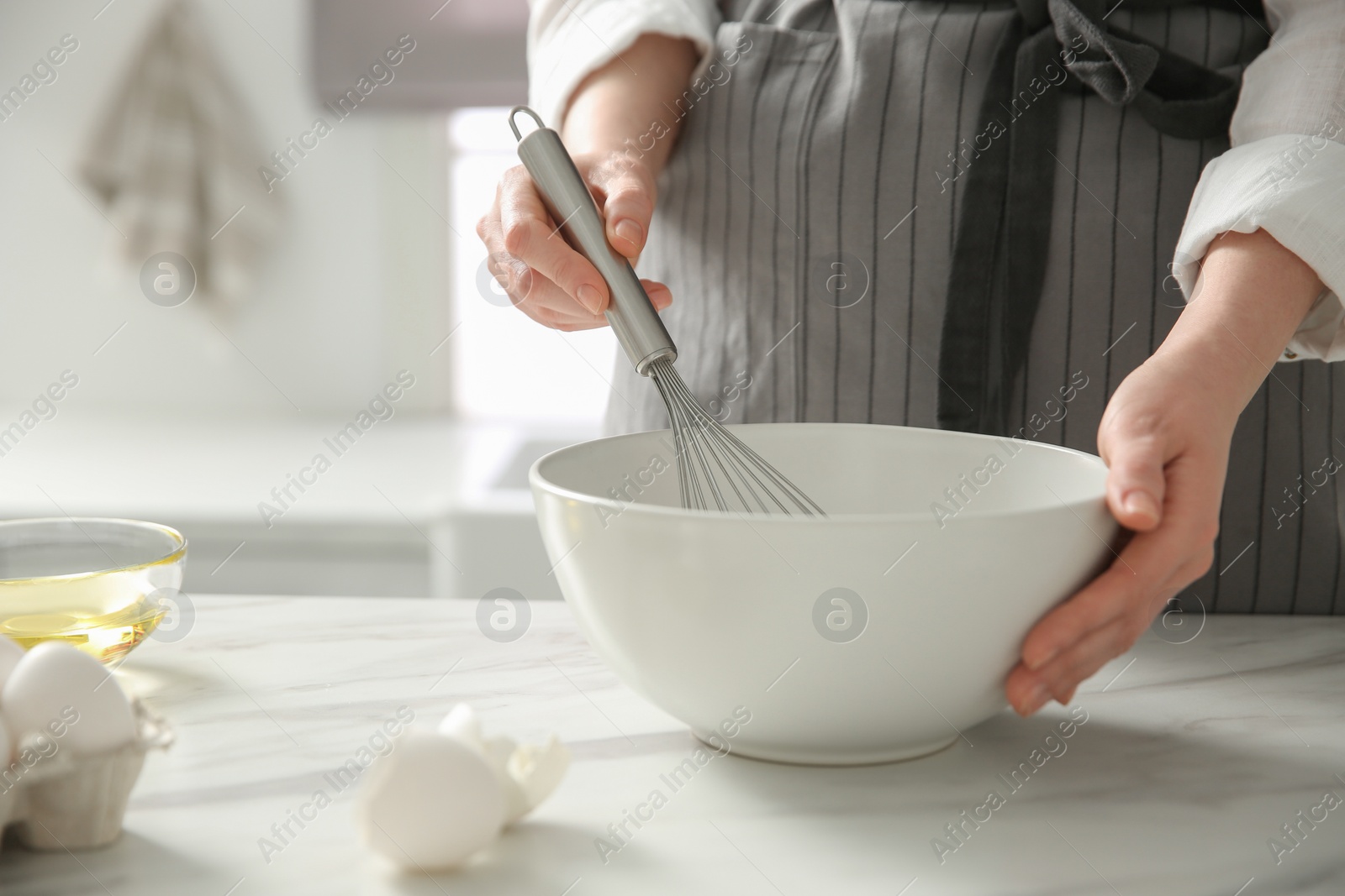 Photo of Woman making dough at table in kitchen, closeup