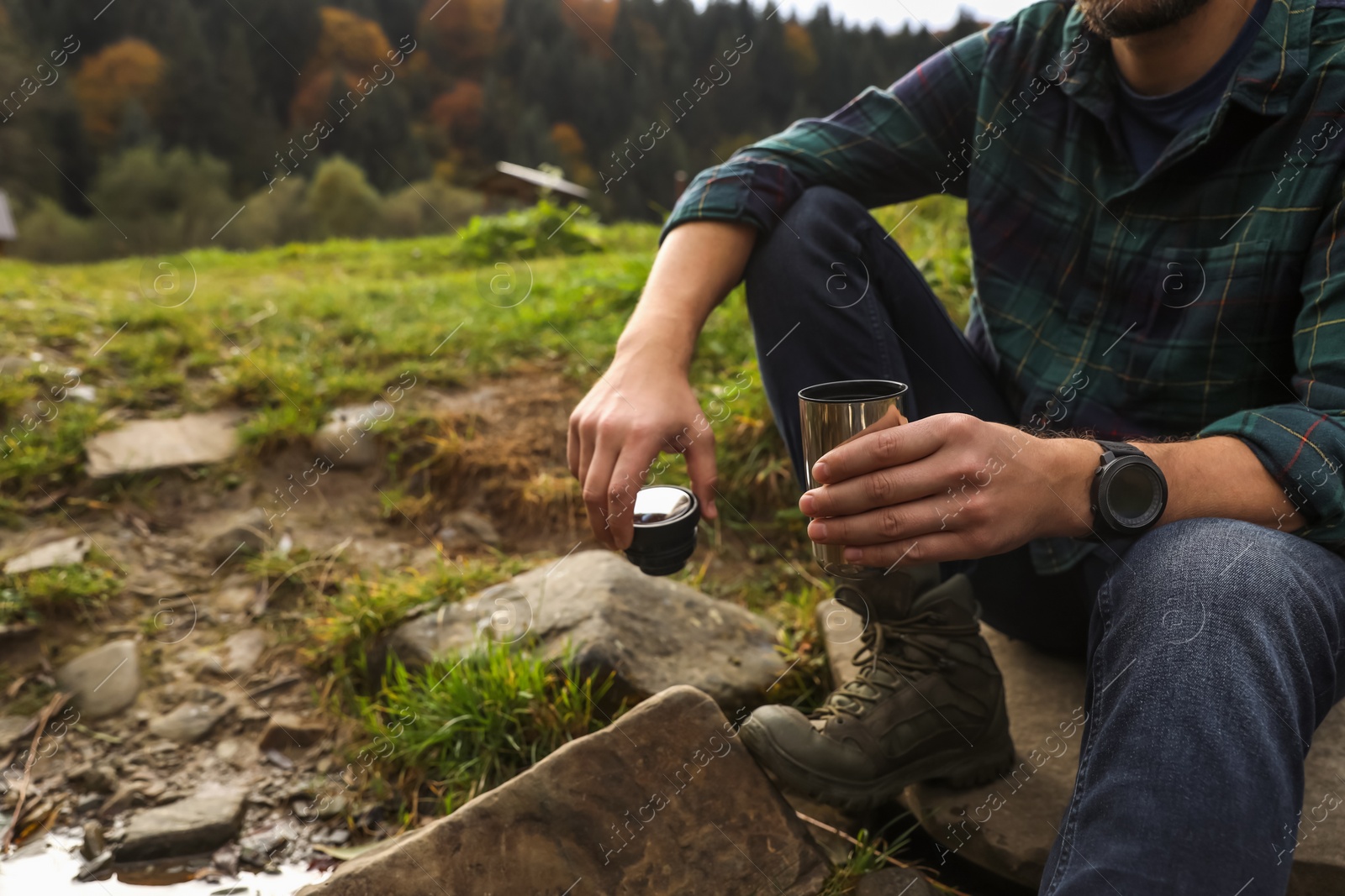 Photo of Man with thermo tumbler in nature, closeup. Space for text