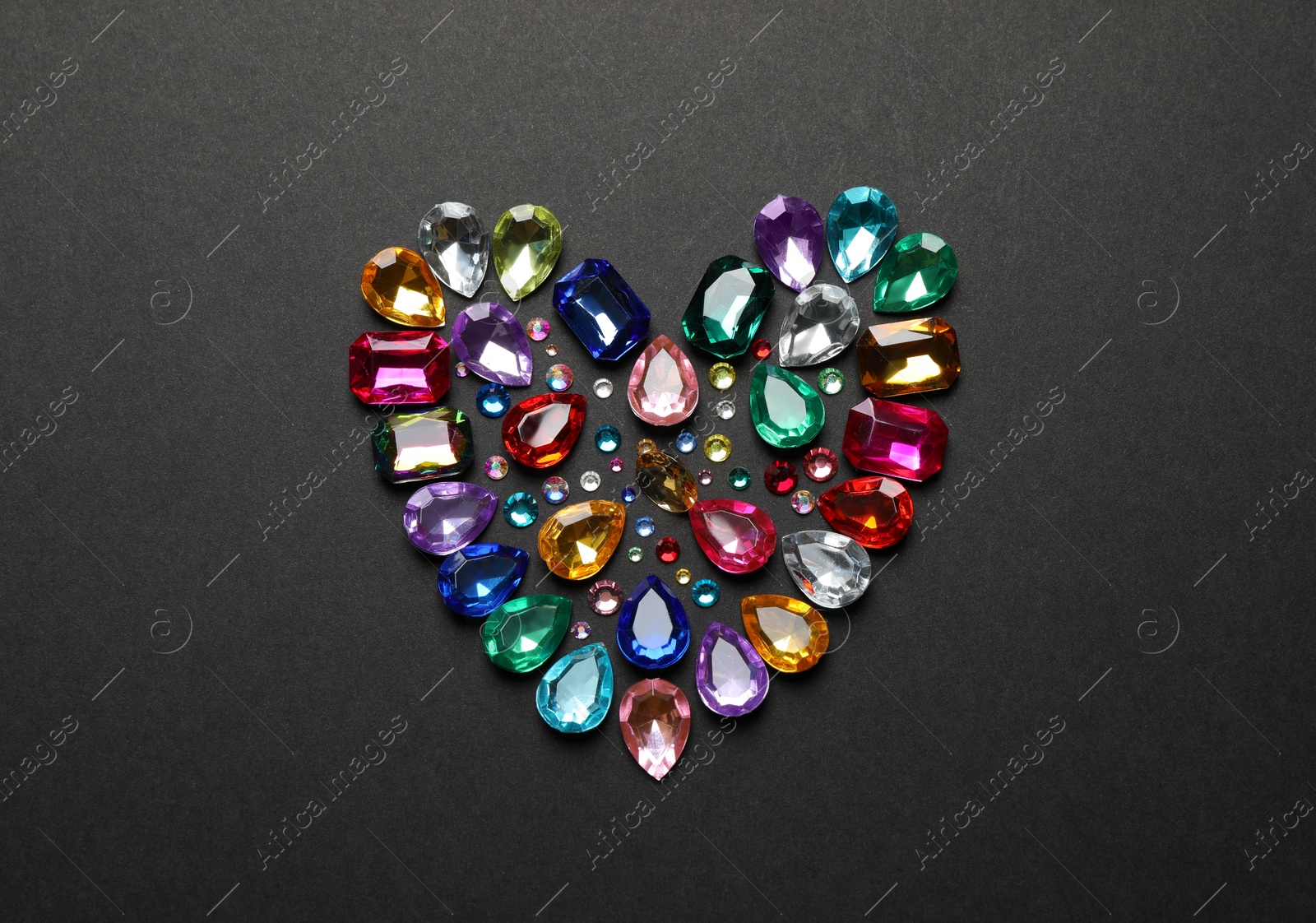 Photo of Heart made of beautiful gemstones on dark background, flat lay