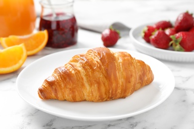 Photo of Tasty breakfast with croissant served on white marble table