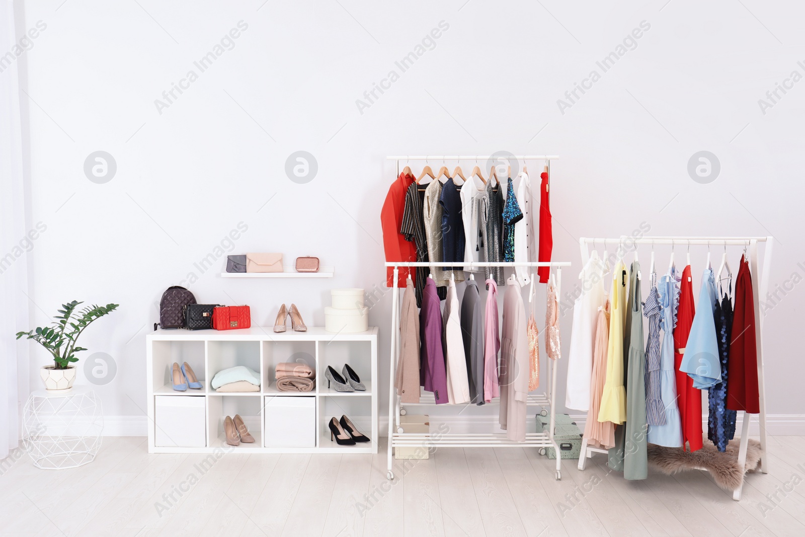 Photo of Racks with clothes in stylish dressing room interior