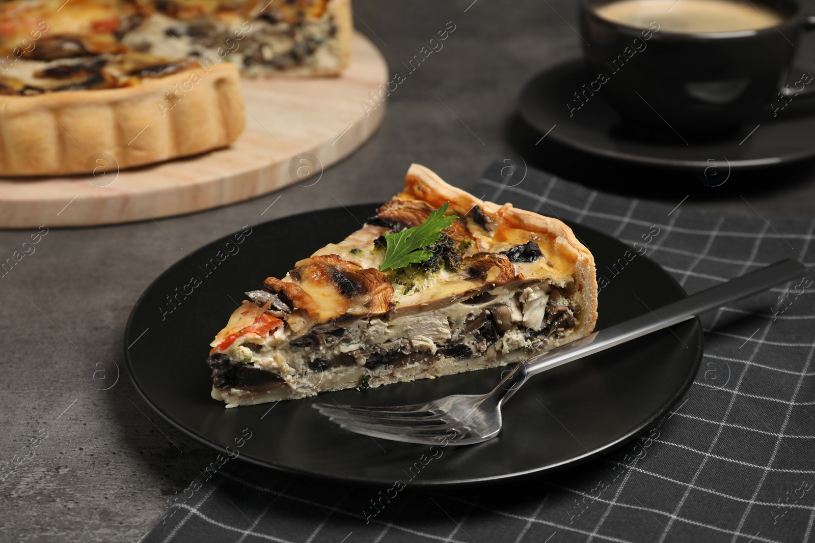 Photo of Piece of delicious quiche with mushrooms on grey table