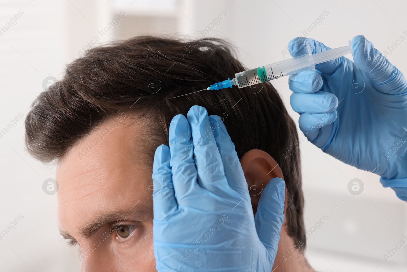 Photo of Trichologist giving injection to patient in clinic, closeup