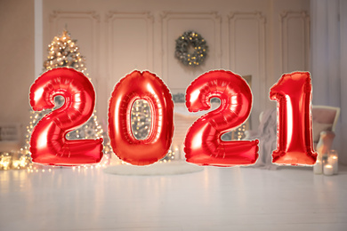 Image of Red foil 2021 balloons in festive room interior 