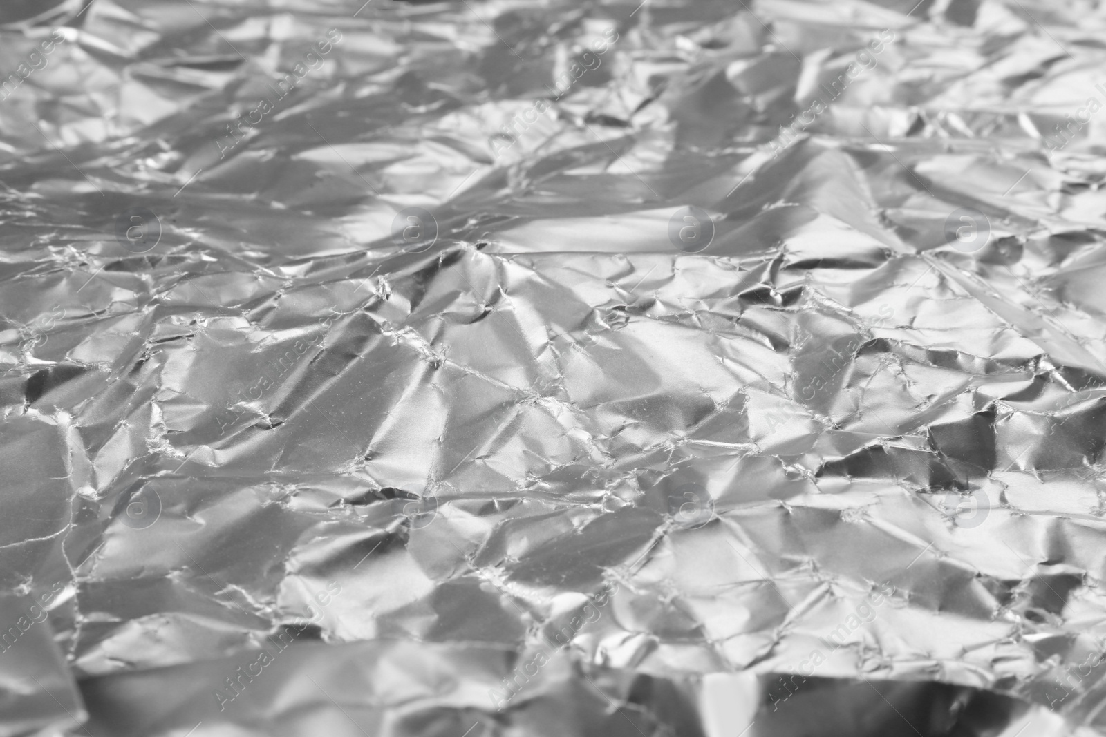 Photo of Crumpled silver foil as background, closeup view