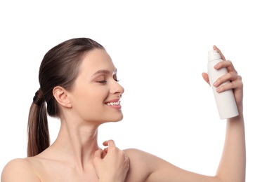 Young woman applying thermal water on face against white background. Cosmetic product