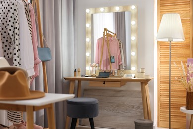 Makeup room. Stylish wooden dressing table with mirror and chair indoors