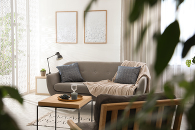 Photo of Modern living room interior with comfortable sofa near light wall