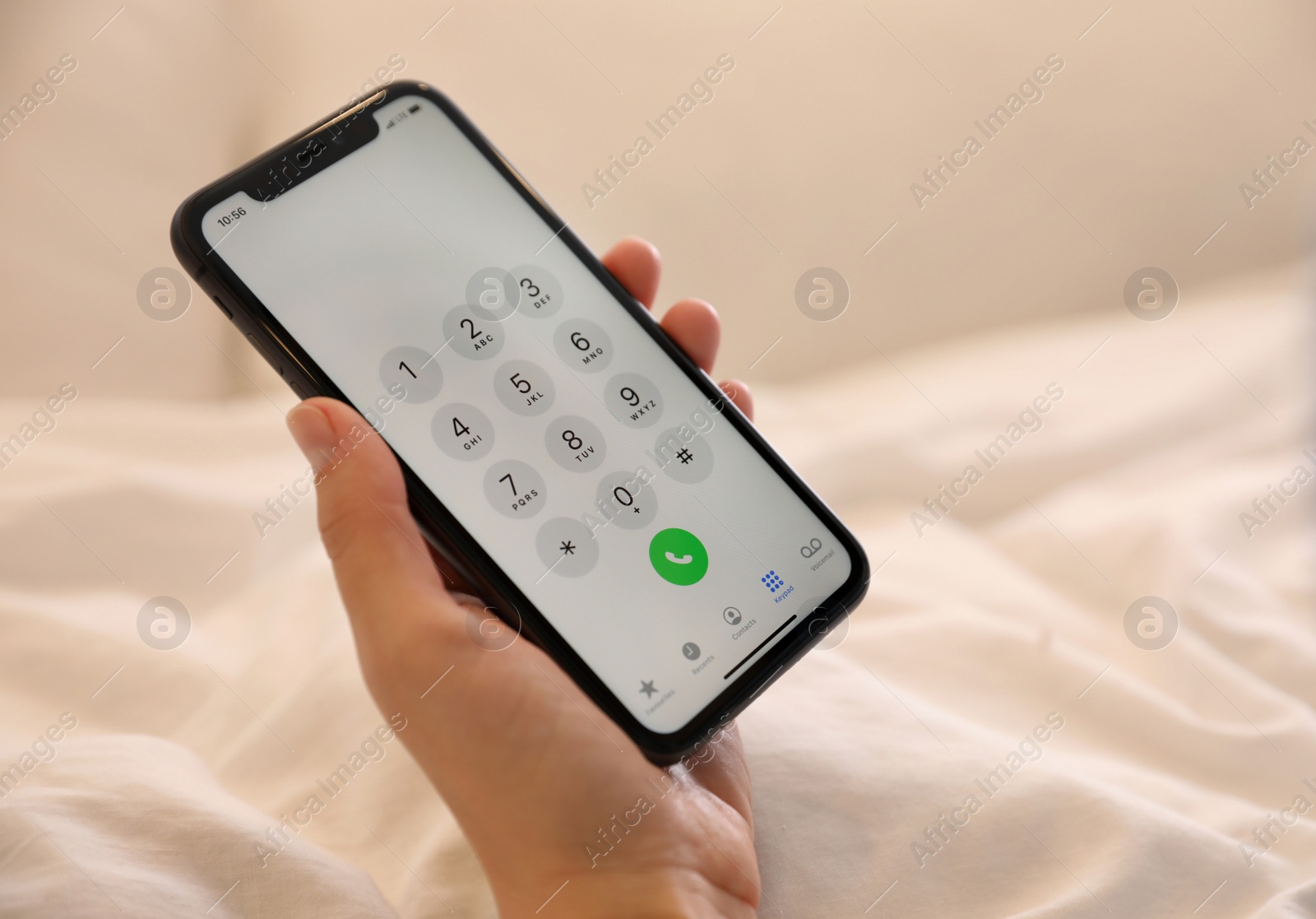 Photo of MYKOLAIV, UKRAINE - MARCH 16, 2020: Woman holding iPhone 11 with keypad on screen indoors, closeup