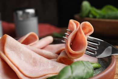 Photo of Tasty ham with spinach on table, closeup