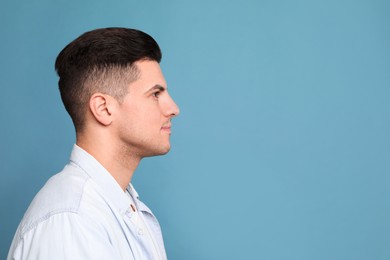 Photo of Profile portrait of man on light blue background. Space for text