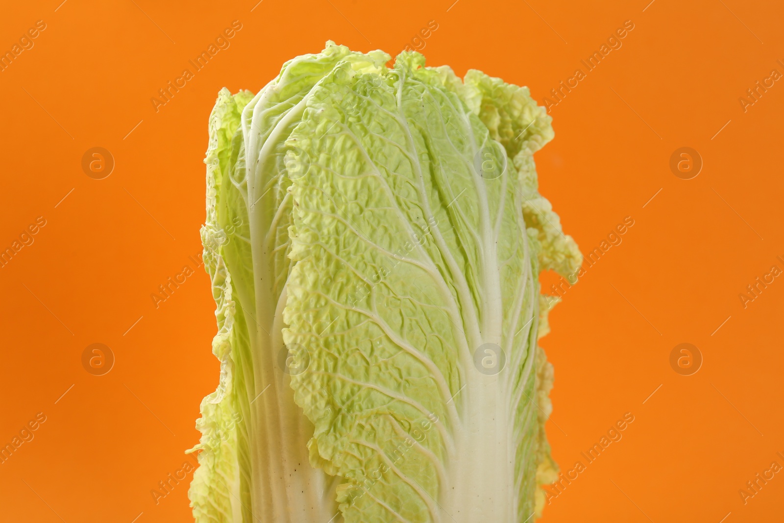 Photo of Fresh ripe Chinese cabbage on orange background, closeup