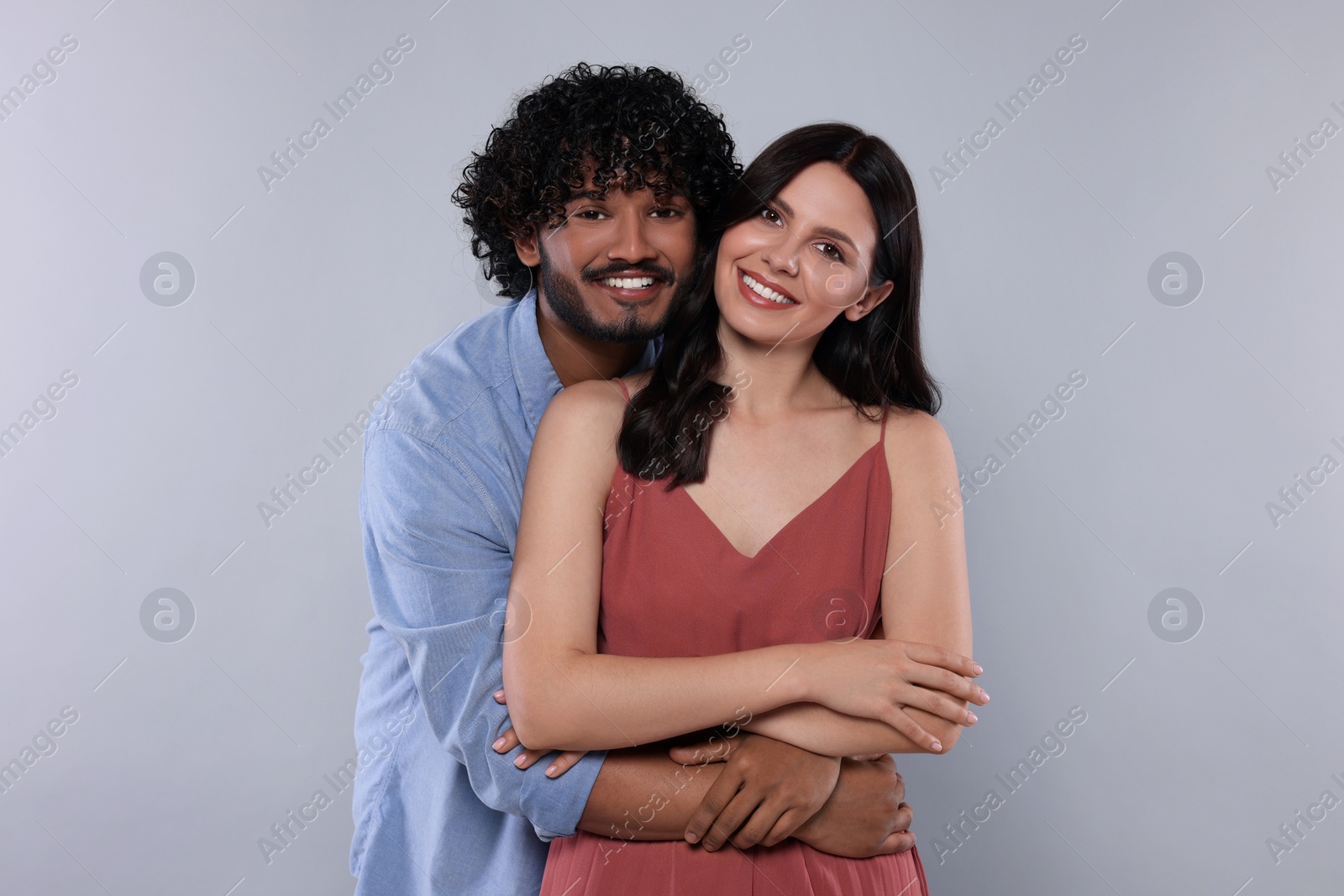 Photo of International dating. Happy couple hugging on light grey background