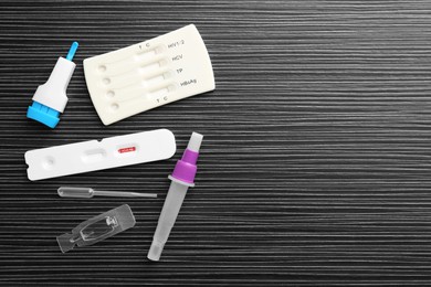 Photo of Disposable express test kits on black wooden table, flat lay. Space for text