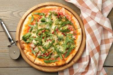 Photo of Board with delicious vegetarian pizza on wooden table, top view