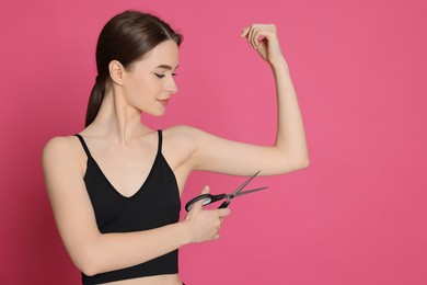 Photo of Slim young woman with scissors on pink background, space for text. Weight loss surgery