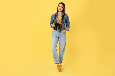 Photo of Professional photographer working on yellow background in studio