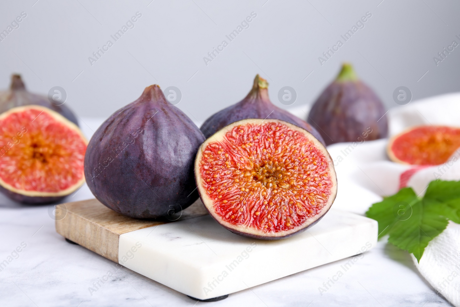 Photo of Fresh ripe purple figs on white marble table