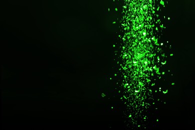 Image of St. Patrick day. Shiny green glitter on black background, bokeh effect