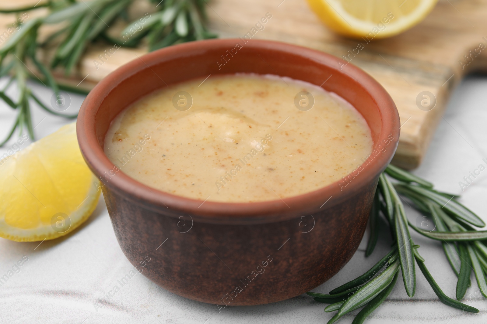 Photo of Delicious turkey gravy, rosemary and lemon on table, closeup