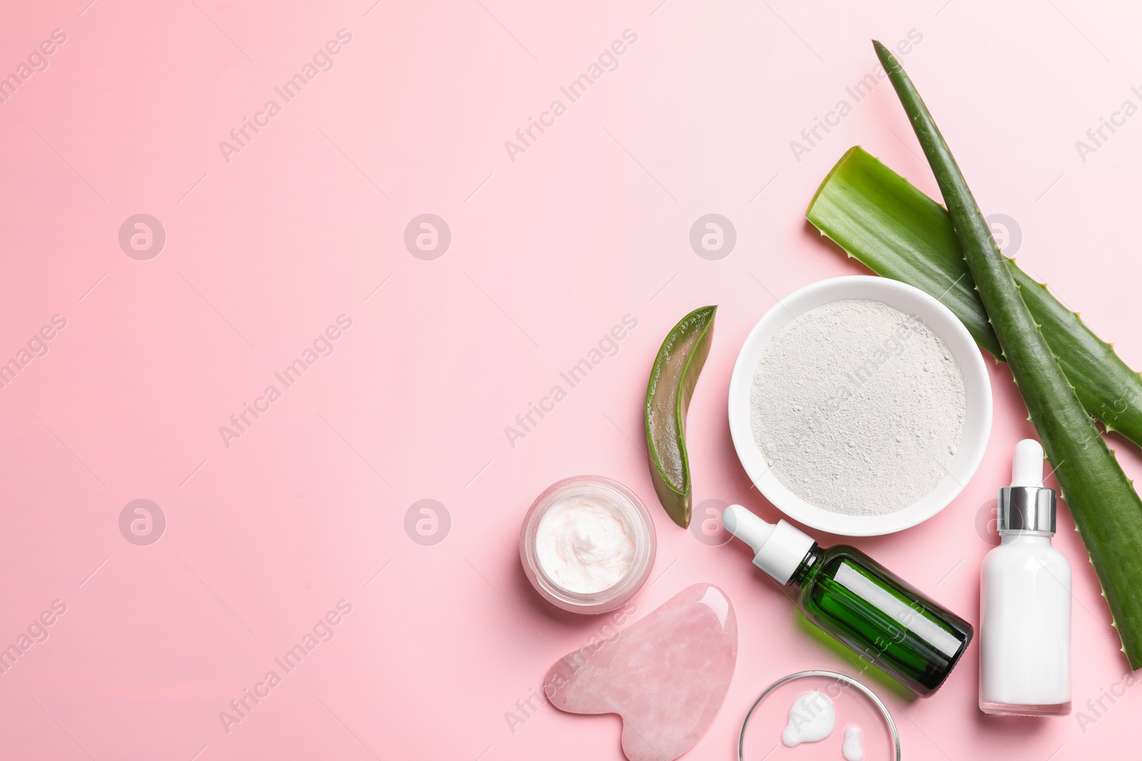 Photo of Flat lay composition with cosmetic products and cut aloe leaves on pink background. Space for text