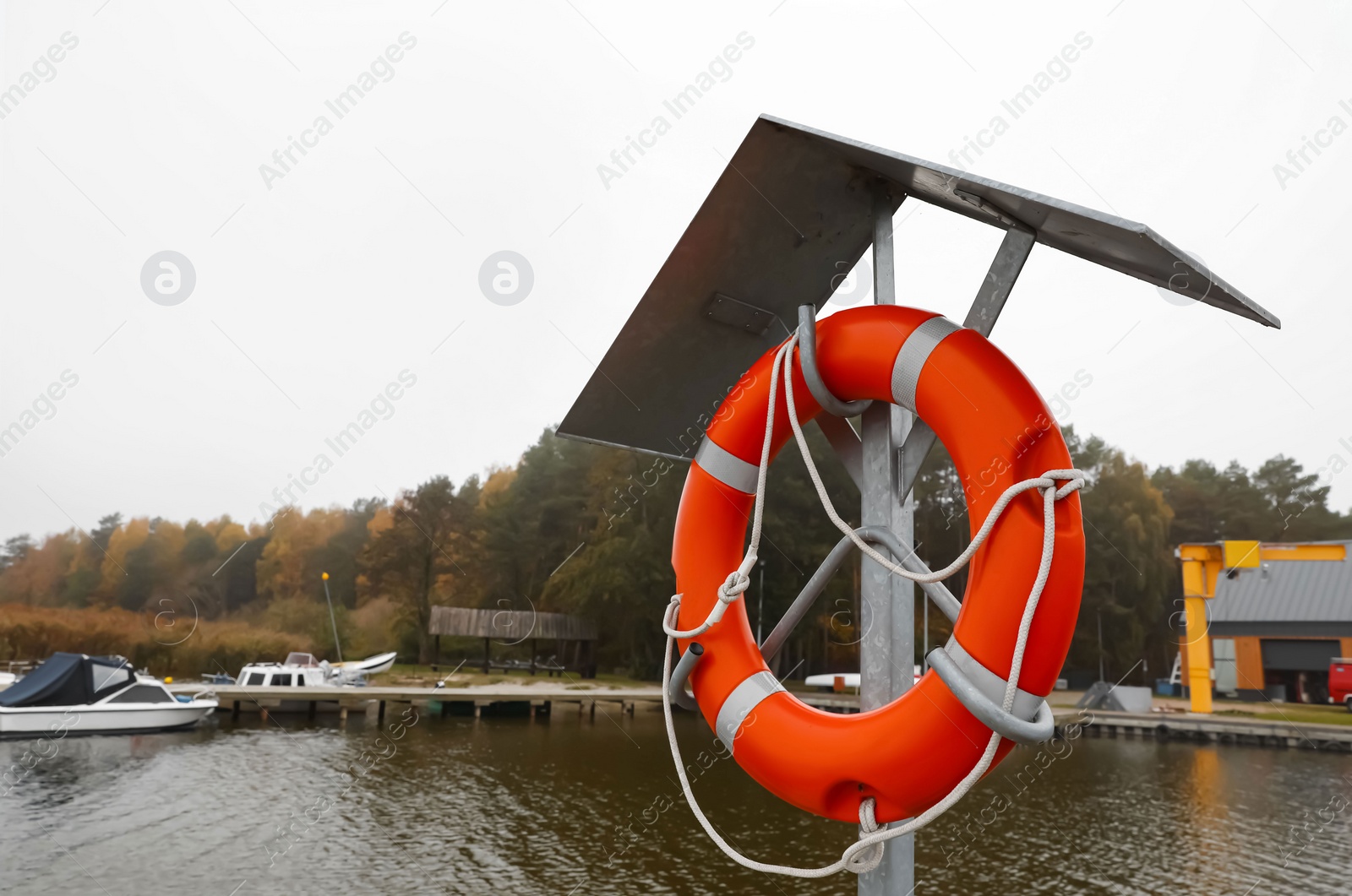 Photo of Orange lifebuoy near river outdoors, space for text